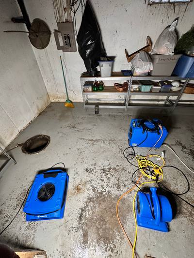 Air movers on a wet basement floor in an older Prairie Village, KS home