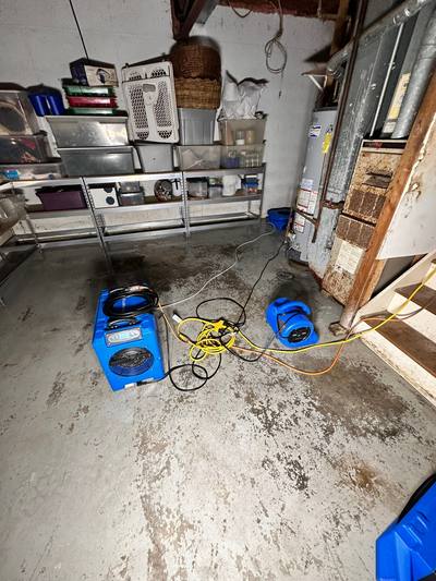 Drying equipment set up across an unfinished basement in Prairie Village, KS