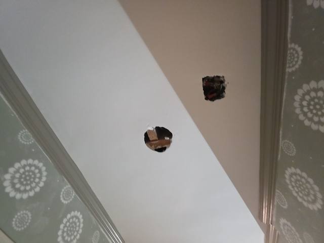 Small drying holes in a ceiling below a bathroom leak in Roeland Park, KS