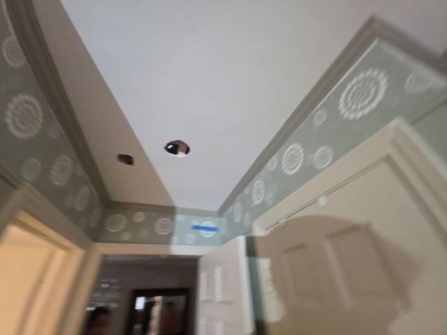 Small inspection holes cut in a ceiling below a bathroom leak in Roeland Park, KS